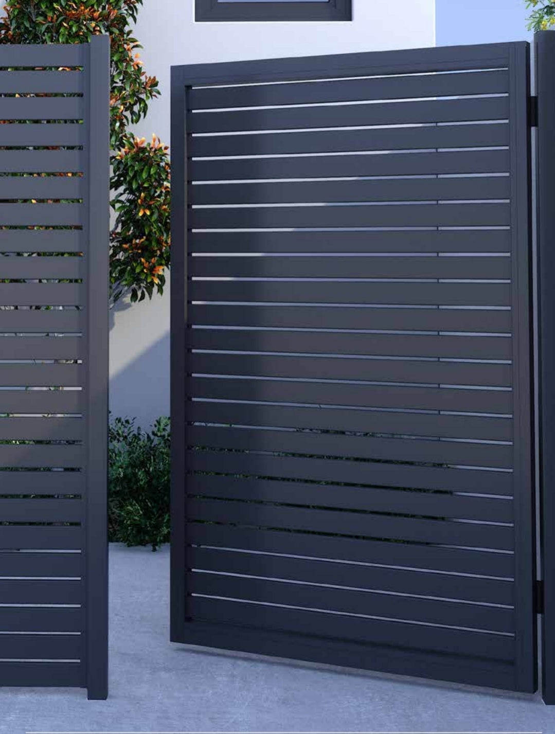 Dark gray slatted gate with a white wall and greenery in the background