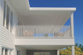 Balcony of a house with white railings and blue sky