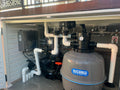 Pump and filtration system with Waterco branding in an outdoor setting.
