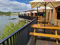 Outdoor seating area with tables and umbrellas by a waterfront